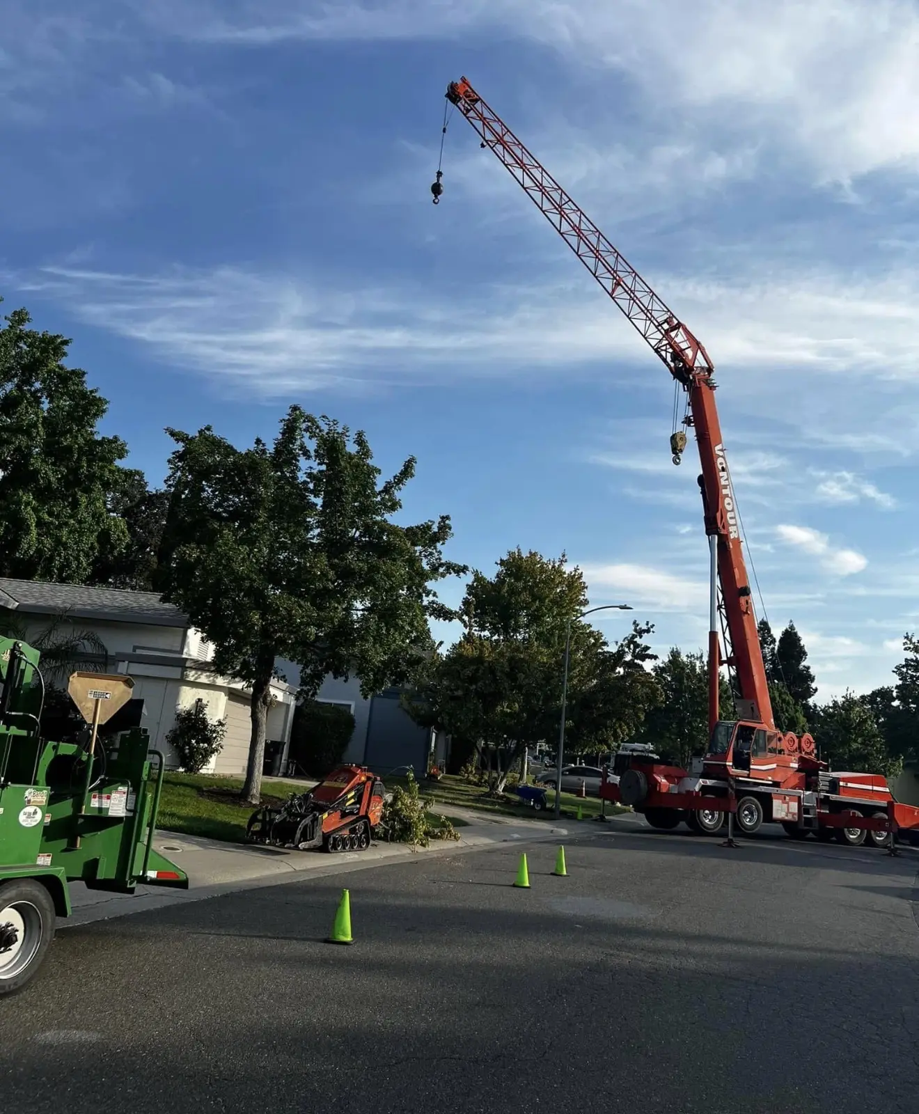 Large red crane set up for residential tree work